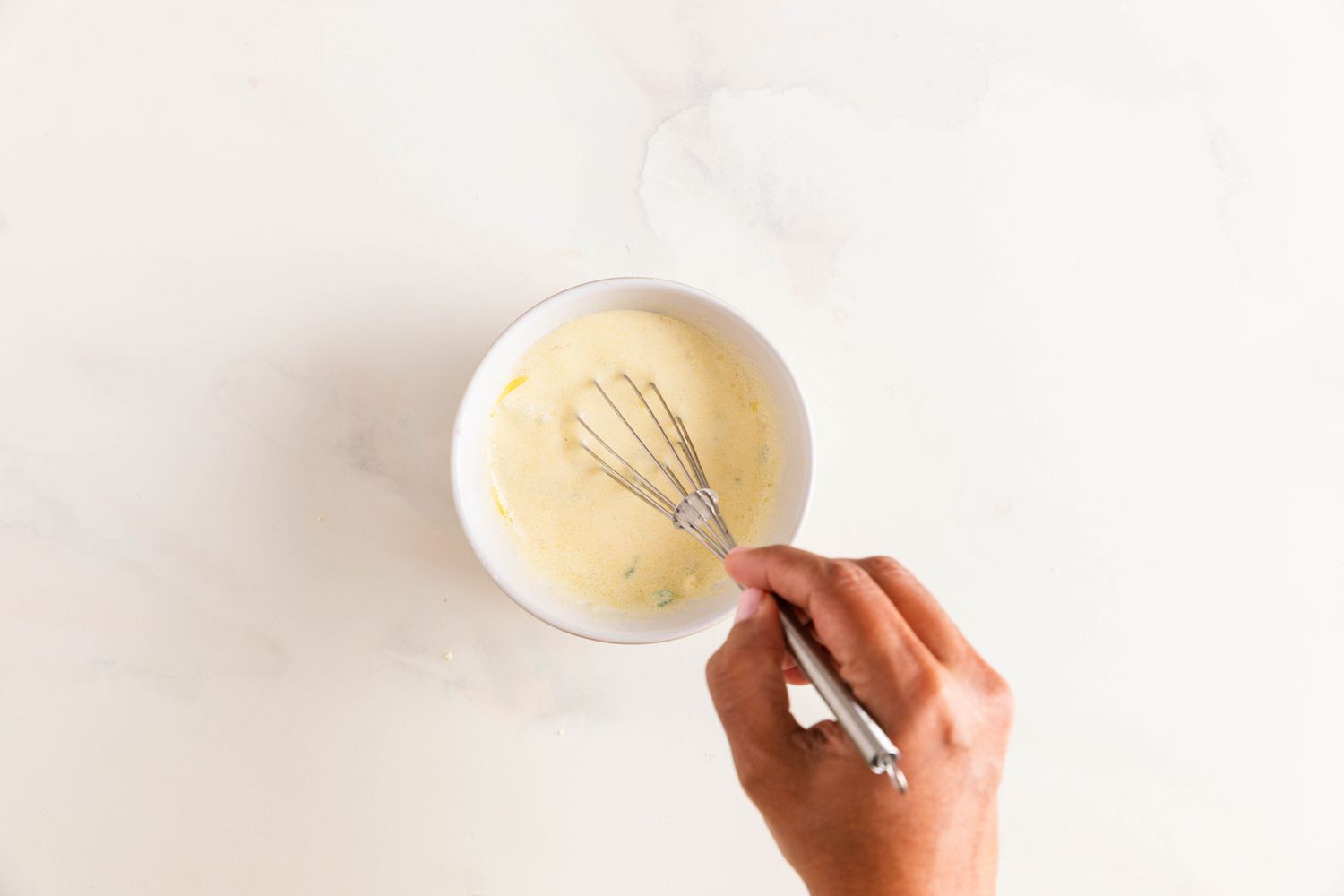 Creamy jalapeno-lime dresing whisked in a bowl for banh mi salad recipe